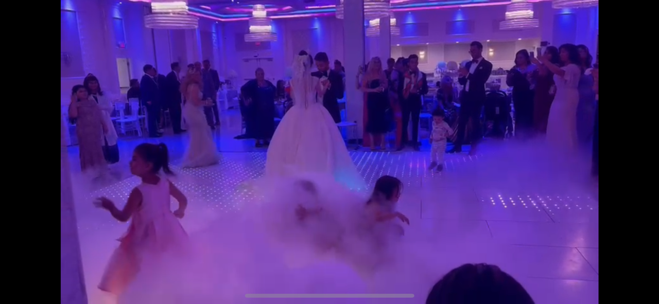 Wedding couple and guests dancing under purple lights